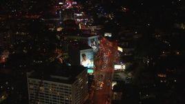 HD stock footage aerial video tilt to and fly over Sunset Strip billboards and traffic at night in West Hollywood, California Aerial Stock Footage | CAP_018_140