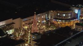 HD stock footage aerial video of circling a Christmas tree at The Grove shopping mall at night in Los Angeles, California Aerial Stock Footage | CAP_018_148