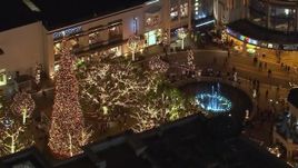 HD stock footage aerial video of orbiting a fountain at The Grove shopping mall at night in Los Angeles, California Aerial Stock Footage | CAP_018_152