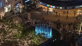 HD stock footage aerial video of orbiting fountain at The Grove shopping mall, decorated for the holidays at night in Los Angeles, California Aerial Stock Footage | CAP_018_156