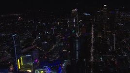 HD stock footage aerial video orbit hotel under construction at night, reveal Downtown Los Angeles skyline, California Aerial Stock Footage | CAP_018_198