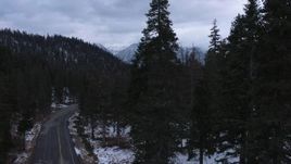 4K stock footage aerial video of snowy mountains, descend by road through evergreen forest, Inyo National Forest, California Aerial Stock Footage | CAP_019_012