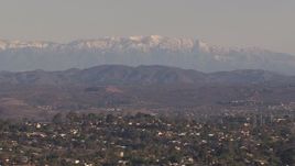 HD stock footage aerial video of snow mountains in the distance, seen from hillside homes, Carlsbad, California Aerial Stock Footage | CAP_021_021