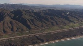 HD stock footage aerial video of panning across I-5 between mountains and coastal cliffs, San Clemente, California Aerial Stock Footage | CAP_021_044