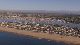 HD stock footage aerial video of flying by the beach and bay by coastal neighborhoods, Newport Beach, California Aerial Stock Footage | CAP_021_076