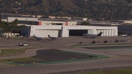 HD stock footage aerial video of civilian jets and helicopters by a Burbank Airport hangar, California Aerial Stock Footage | CAP_021_133