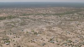 HD stock footage aerial video of flying over a village with the savanna in the distance, Zimbabwe Aerial Stock Footage | CAP_026_069