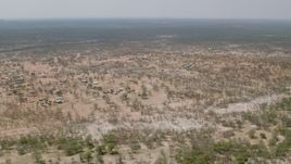 HD stock footage aerial video of flying over a village with the savanna in the background, Zimbabwe Aerial Stock Footage | CAP_026_070