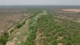 HD stock footage aerial video of following a nearly dried up river past trees in savanna, Zimbabwe Aerial Stock Footage | CAP_026_074