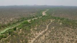 HD stock footage aerial video of flying by a dry riverbed and trees in savanna, Zimbabwe Aerial Stock Footage | CAP_026_077
