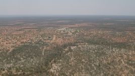 HD stock footage aerial video of passing by a village surrounded by savanna, Botswana Aerial Stock Footage | CAP_026_082