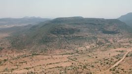 HD stock footage aerial video of a village beside green mountains in Zimbabwe Aerial Stock Footage | CAP_026_102
