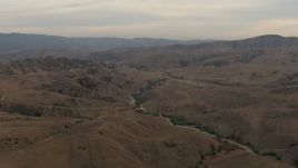 HD aerial stock footage of flying by mountain range, scattered vegetation, overcast, Chino Hills, California Aerial Stock Footage | CBAX01_050