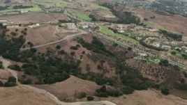 HD aerial stock footage of fly over mountain range, revealing golf course, homes, Chino Hills, California Aerial Stock Footage | CBAX01_054