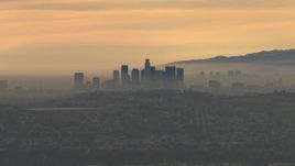 HD aerial stock footage of flying by smoggy skyline, cloudy, Downtown Los Angeles, California, sunset Aerial Stock Footage | CBAX01_080