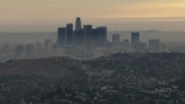 HD aerial stock footage of the smoggy skyline, hillside neighborhood, Downtown Los Angeles, California, sunset Aerial Stock Footage | CBAX01_096