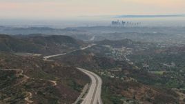 HD aerial stock footage of a view of hazy downtown from Glendale hills, Downtown Los Angeles, California  Aerial Stock Footage | CBAX01_115