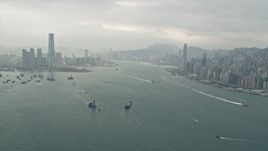 4K aerial stock footage of ships sailing Victoria Harbor between Kowloon and Hong Kong Island, China Aerial Stock Footage | DCA02_014