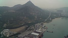 4K aerial stock footage tilt from warehouse buildings to reveal Castle Peak and waterfront apartments, New Territories, Hong Kong, China Aerial Stock Footage | DCA02_057