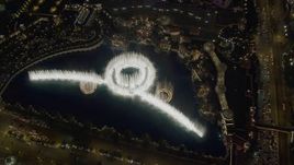4K aerial stock footage of flying away from Bellagio Fountain water show, revealing The Bellagio, Las Vegas, Nevada Night Aerial Stock Footage | DCA03_025