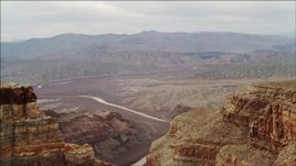 4K aerial stock footage of flying around a rock formation in Grand Canyon, revealing Colorado River, Arizona Aerial Stock Footage | DCA04_048