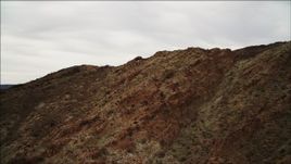 4K aerial stock footage of flying over a mountain ridge near Lake Mead, with goats running, Nevada Aerial Stock Footage | DCA04_090