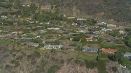 4K aerial stock footage of flying by homes on a cliff above the coast, Malibu, California Aerial Stock Footage | DCA05_107