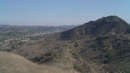 4K aerial stock footage of flying over a hill, revealing Agoura Hills, California Aerial Stock Footage | DCA05_148