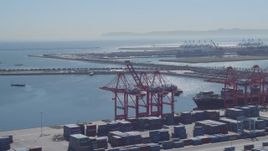 4K aerial stock footage of flying by cargo containers, cranes, reveal cargo ship, Port of Long Beach, California Aerial Stock Footage | DCA06_041