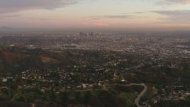 4K aerial stock footage of flying over Hollywood Hills, revealing Downtown skyline, Los Angeles, California, sunset Aerial Stock Footage | DCA07_001
