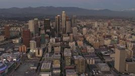 4K aerial stock footage of flying over buildings, tilt up, reveal Downtown skyscrapers, Los Angeles, California, twilight Aerial Stock Footage | DCA07_010