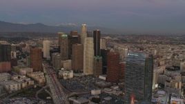 4K aerial stock footage of flying by Downtown skyscrapers, mountains in the distance, Los Angeles, California, twilight Aerial Stock Footage | DCA07_013