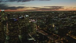 4K aerial stock footage of flying by Downtown skyscrapers, coast and clouds in the distance, Los Angeles, California, twilight Aerial Stock Footage | DCA07_054