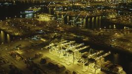 4K aerial stock footage tilt from cargo ship to wider view of Port of Long Beach, California, night Aerial Stock Footage | DCA07_145