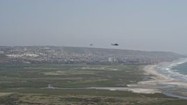 4K aerial stock footage of tracking two military helicopters flying near the coast, Imperial Beach, California Aerial Stock Footage | DCA08_035