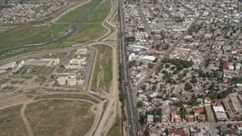 4K aerial stock footage of following a border highway and fence on the US/Mexico Border, Tijuana Aerial Stock Footage | DCA08_046