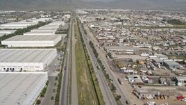 4K aerial stock footage of flying over border fence past warehouses, US/Mexico Border, Tijuana Aerial Stock Footage | DCA08_069E
