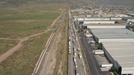 4K aerial stock footage fly over warehouses and trucks by border fence, US/Mexico Border, Tijuana Aerial Stock Footage | DCA08_072E