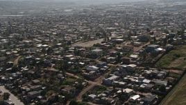 4K aerial stock footage of urban neighborhoods by the border fence, US/Mexico Border, Tijuana Aerial Stock Footage | DCA08_077