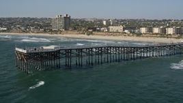 4K aerial stock footage of flying by beach to orbit Crystal Pier, flyby beachside condos in Pacific Beach, California Aerial Stock Footage | DCA08_147E