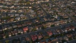 4K aerial stock footage of a reverse view of tract homes in the suburbs, Clairemont Mesa East, California, Sunset Aerial Stock Footage | DCA08_271