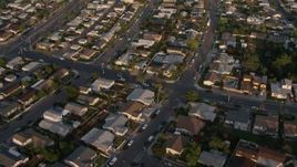4K aerial stock footage of a reverse view of suburban tract homes, Bay Ho, California, Sunset Aerial Stock Footage | DCA08_274