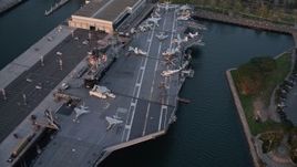 4K aerial stock footage reveal and orbit aircraft carrier, USS Midway in Downtown San Diego, California at sunset Aerial Stock Footage | DCA08_304E