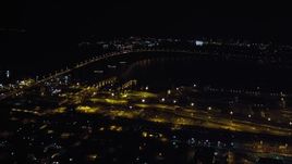 4K aerial stock footage of panning across the Coronado Bridge, the bay, and Coronado, California at night Aerial Stock Footage | DCA08_358