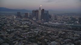 5K aerial stock footage tilt from Pico-Union streets to reveal Downtown Los Angeles skyline and full moon at twilight, California Aerial Stock Footage | DCLA_070