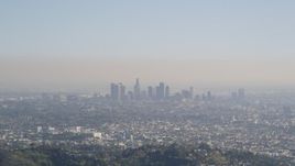 5K aerial stock footage fly over a green mountain to reveal Downtown Los Angeles skyline, California Aerial Stock Footage | DCLA_107