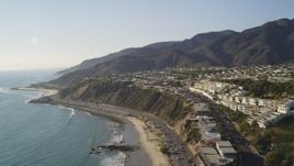5K aerial stock footage tilt from Highway 1 and beach to reveal hilltop neighborhoods near ocean in Malibu, California Aerial Stock Footage | DCLA_137