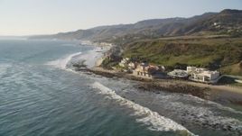 5K aerial stock footage tilt from ocean waves to reveal oceanfront homes in Malibu, California Aerial Stock Footage | DCLA_155