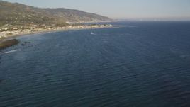 5K aerial stock footage fly over seagulls over the ocean and tilt to reveal Malibu, California Aerial Stock Footage | DCLA_170