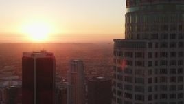 5K aerial stock footage flyby US Bank Tower in Downtown Los Angeles with setting sun in the distance, California Aerial Stock Footage | DCLA_234